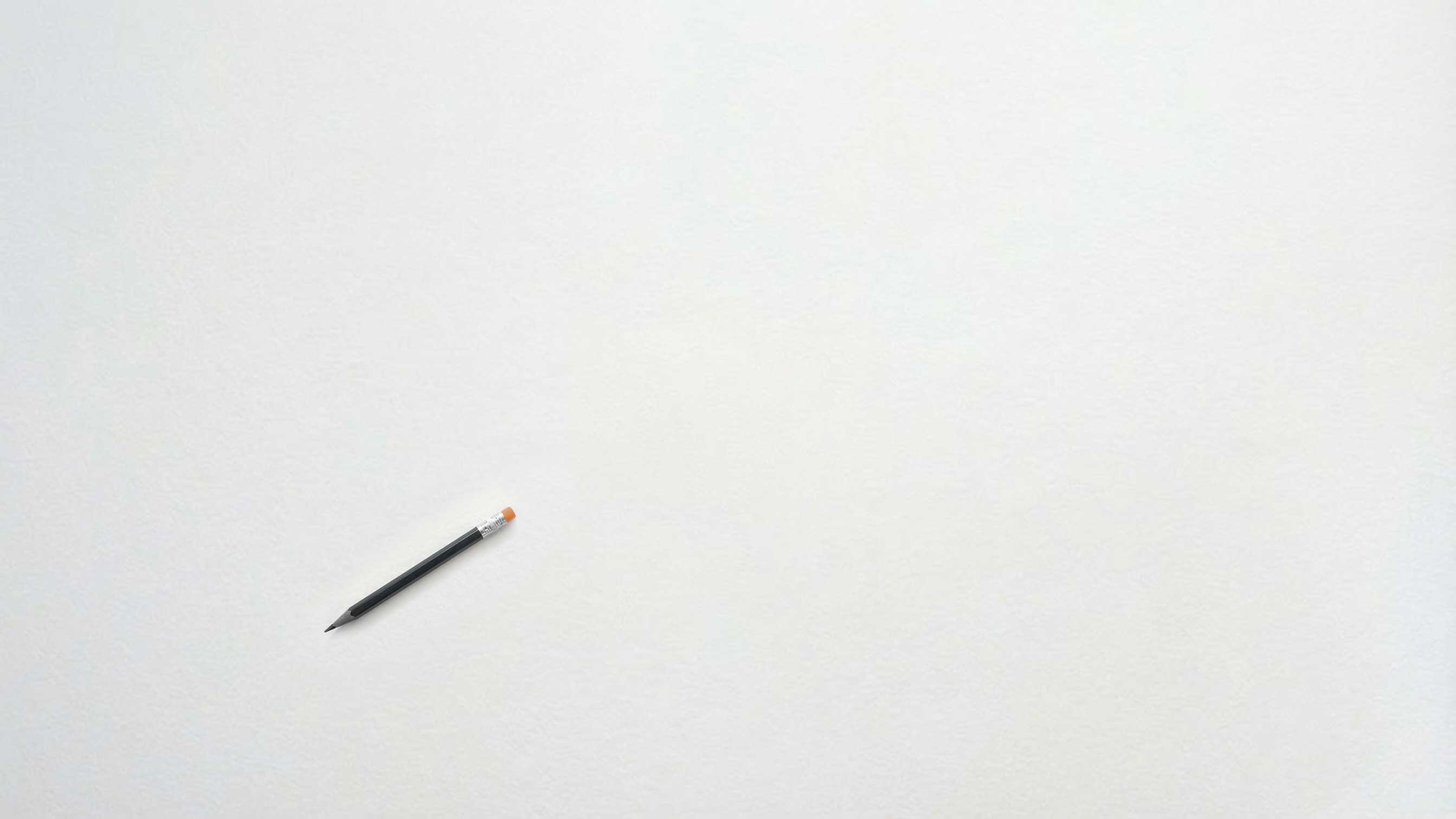 A mostly blank canvas with a single pencil resting on it